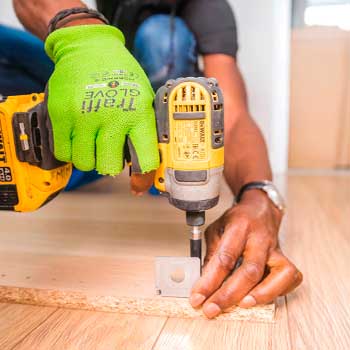 Person using dewalt cordless impact driver on brown board